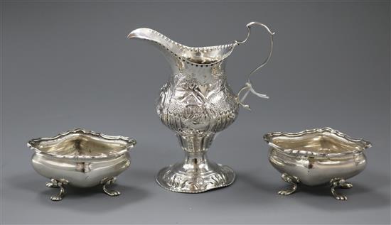 A George III silver cream jug with later embossed decoration and a pair of silver salts.